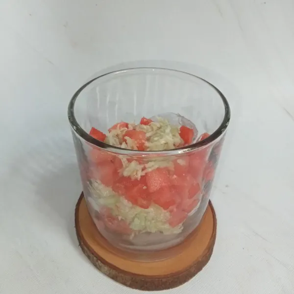 Siapkan gelas dan masukkan es batu, lalu masukkan semangka dan timun.