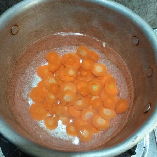 Siapkan panci dan air lalu rebus wortel hingga empuk.