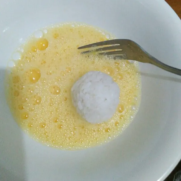 Celupkan bola nasi ke dalam kocokan telur.