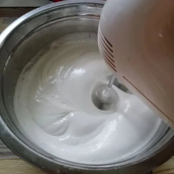 Mixer putih telur, SP, gula pasir, dan garam dengan kecepatan tinggi sampai mengembang dan agak kaku.