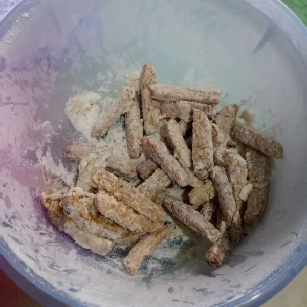 Masukkan tempe dalam bumbu krispy, tutup wadahnya lalu kocok-kocok.