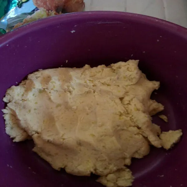 Tuang tepung ke dalam wadah yang berisi ubi aduk rata.