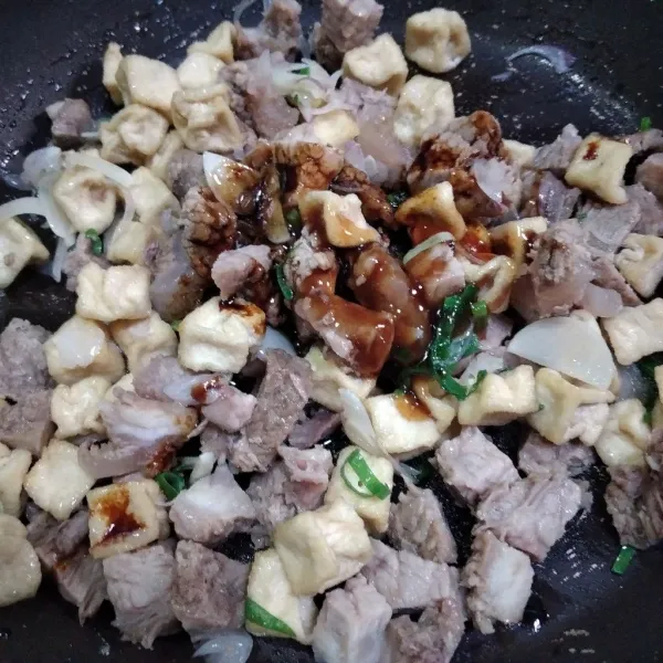 Masukkan irisan daging dan tahu goreng, masukkan saus tiram, kecap asin dan kecap manis, aduk rata.