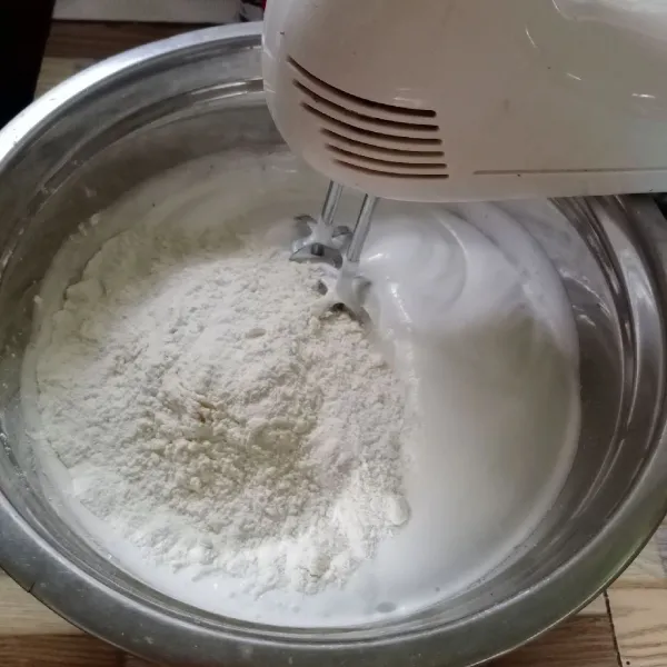 Turunkan speed mixer ke yang paling rendah. Lalu masukkan tepung terigu dan baking powder, kemudian mixer rata.