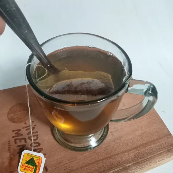Aduk-aduk sampai gula larut dan teh berubah warna, siap disajikan.