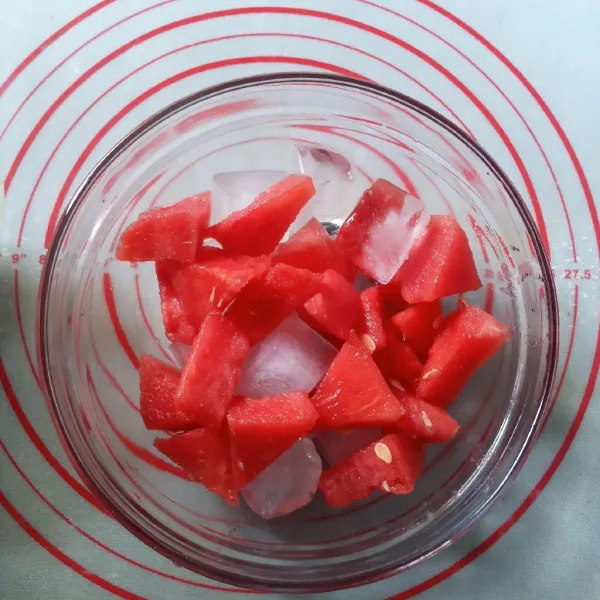 Dalam mangkok besar, masukkan es batu, semangka dan 1 sdm gula pasir.