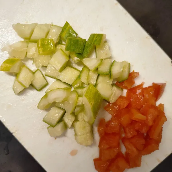 Buang biji bagian dalam mentimun dan tomat, kemudian potong dadu kecil.