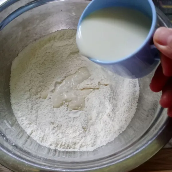 Campur susu uht dan kental manis, aduk rata. Kemudian tuang kedalam campuran tepung.