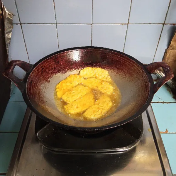 Panaskan minyak, goreng tempe hingga kuning kecokelatan atau sampai matang. Angkat dan tiriskan. Sajikan dengan sambal terasi.