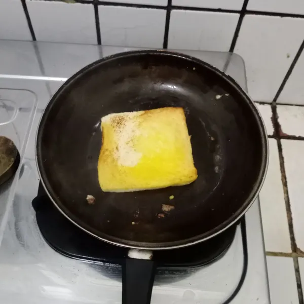 Lelehkan mentega. Panggang roti tawar hingga kecokelatan di kedua sisinya.