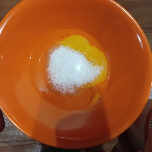 Masukkan gula pasir ke dalam mangkok yg berisikan telur. Aduk rata.