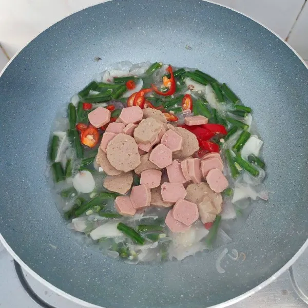 Masukkan potongan cabe rawit, cabe merah besar, sosis dan bakso. Aduk rata.