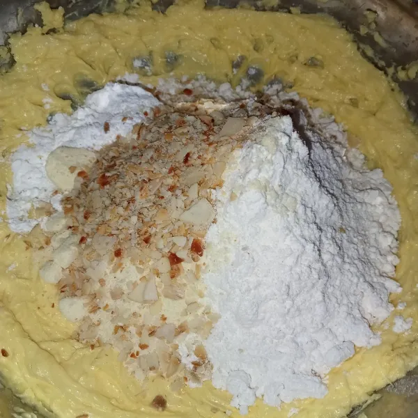 Masukkan tepung terigu, maizena, susu bubuk, pasta pandan dan almond yang sudah di coper kasar.