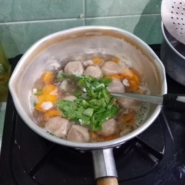 Masukkan daun bawang dan seledri. Masak hingga matang.