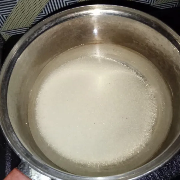 Rebus gula pasir dan air sampai mendidih dan gula larut, biarkan sampai hangat.