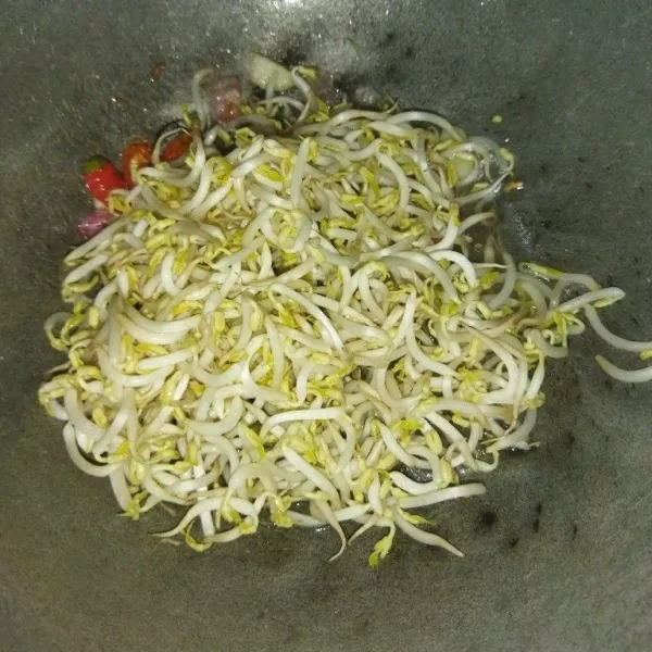 Lalu masukkan cabe rawit, masak hingga cabe layu, lalu tambahkan toge dan air, aduk rata, masak hingga airnya mendidih.