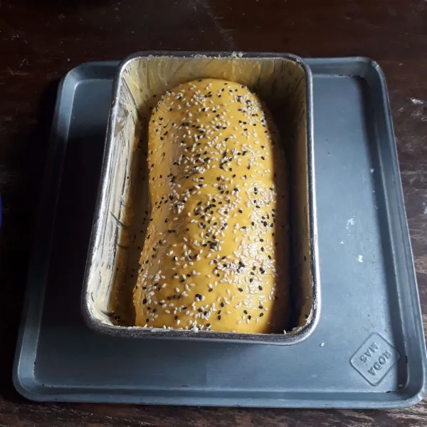 Olesi loyang 20 x 12 cm dengan margarin. Masukkan roti, diamkan 30 menit. Olesi dengan bahan olesan dan taburi wijen.