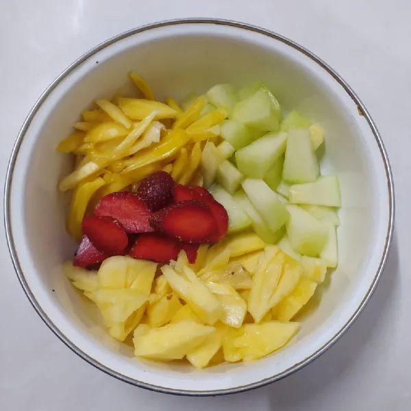 Kupas dan potong-potong buah untuk isian.