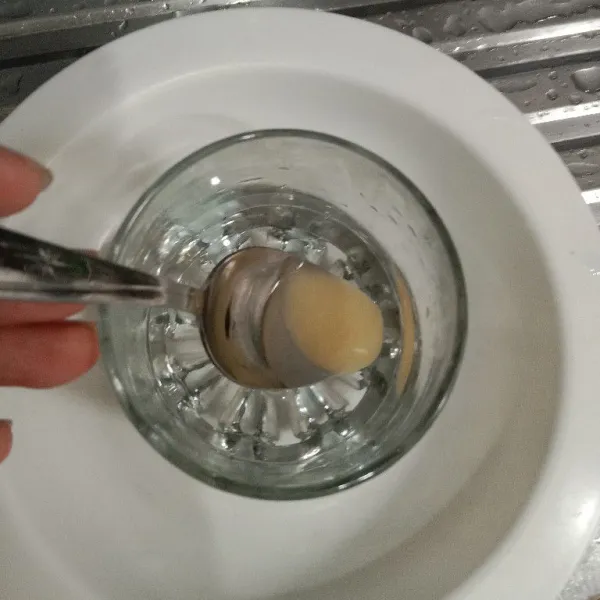 Dalam gelas masukkan 50 ml air. Lalu larutkan madu