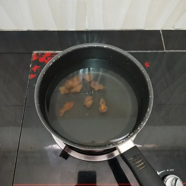 Masak air dan asam jawa di dalam panci hingga mendidih.