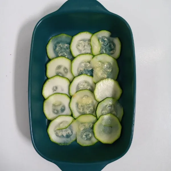 Siapkan wadah tahan panas. Tata zucchini diatasnya.