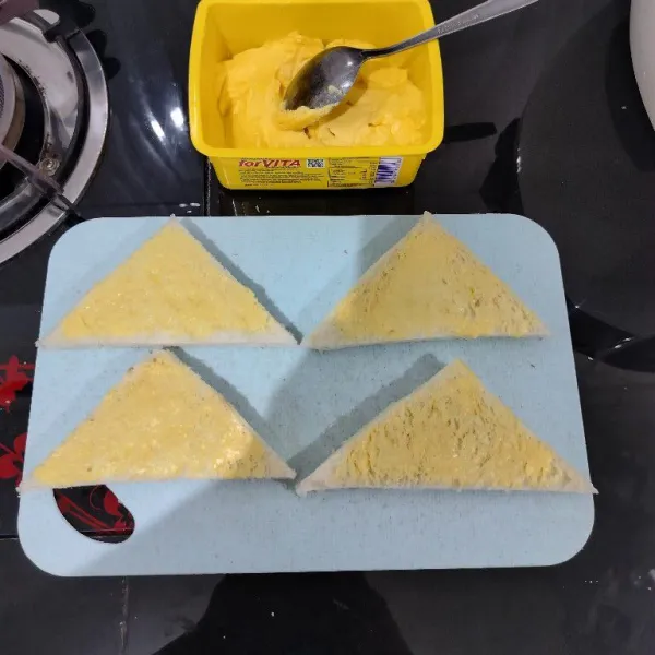 Kemudian oleskan margarin pada semua roti di salah satu sisinya.
