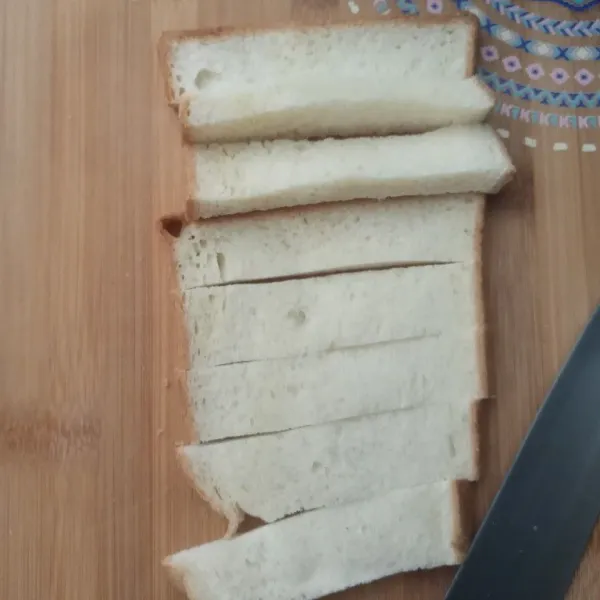 Potong memanjang roti tawar.