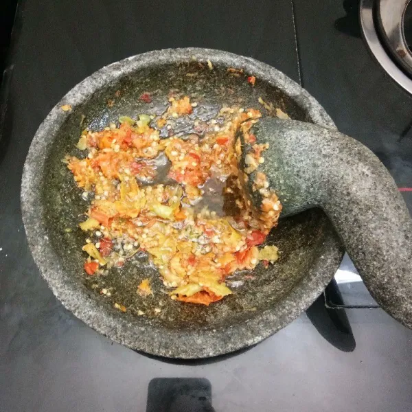 Membuat sambal korek: haluskan kasar saja cabai rawit merah,cabai rawit hijau,bawang putih goreng,dan garam. Lalu masukkan minyak goreng yang panas, aduk rata.