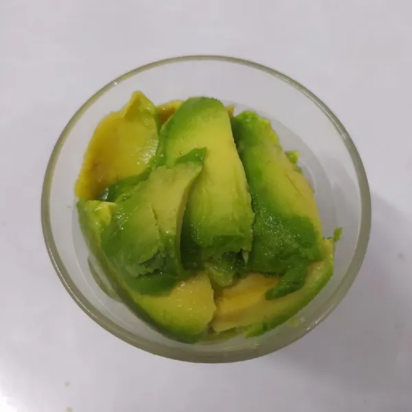 Kerok alpukat taruh dalam gelas saji.