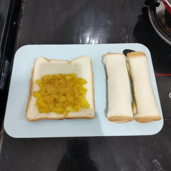 Ambil satu lembar roti tawar, lalu beri isian nanas, lalu gulung. Lakukan hingga roti dan nanas habis.