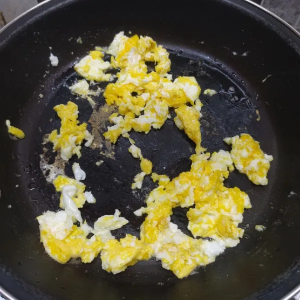Panaskan sedikit minyak, pecahkan telur. Beri sedikit garam, lalu buat orak arik telur. Sisihkan tepi wajan.