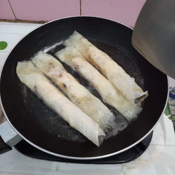 Goreng piscok di minyak panas, bolak-balik sampai kecokelatan dan siap disajikan.