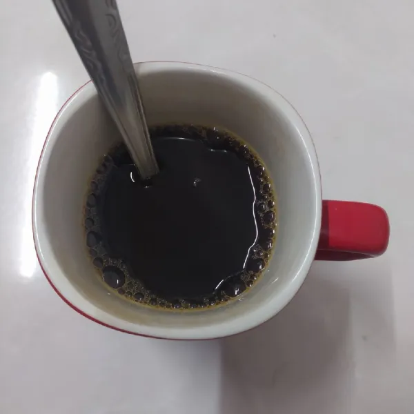 Seduh kopi instan dengan air panas, aduk rata.