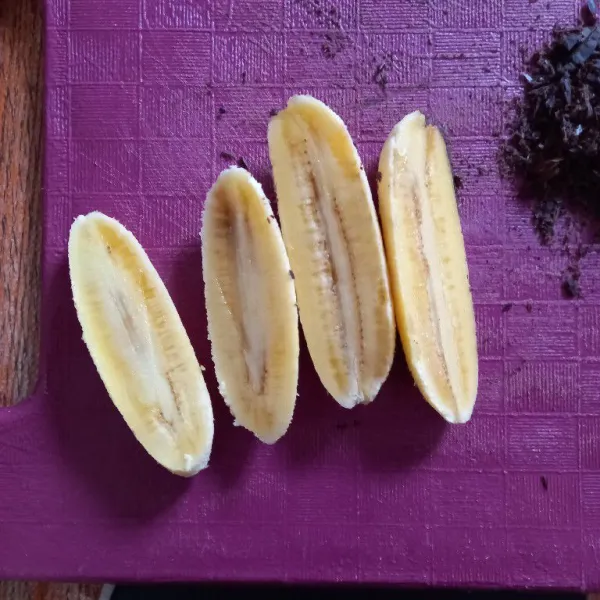 Belah pisang menjadi dua bagian.