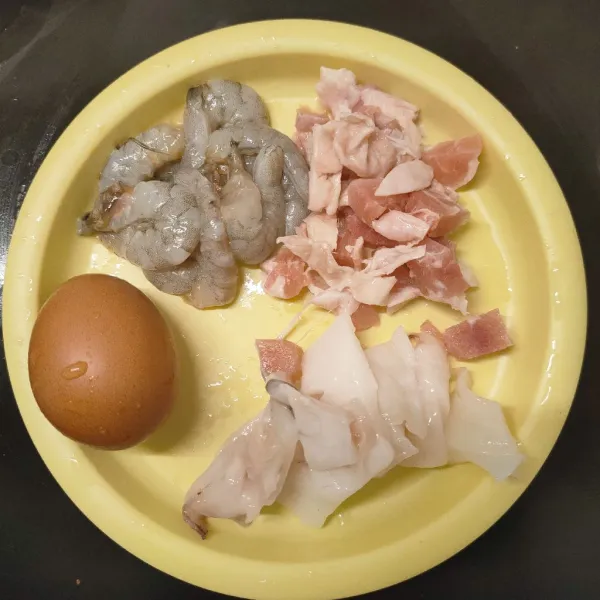 Potong ayam, cumi, dan kupas udang.