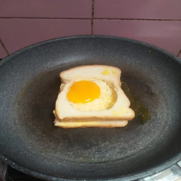 Letakkan roti di atas wajan anti lengket lalu beri telur dan panggang sampai matang.