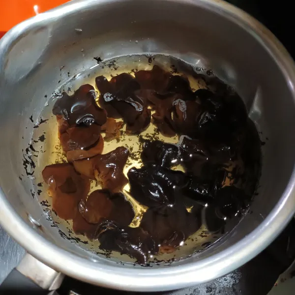 Cuci bersih jamur kuping kering. Lalu rebus sebentar. Diamkan sampai mekar.