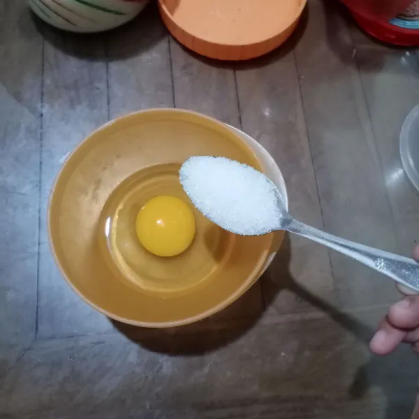 Dalam wadah, masukkan telur dan gula.