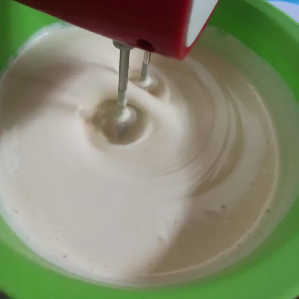 Selanjutnya turunkan kecepatan mixer ke speed sedang masukkan susu kental manis mixer hingga rata.