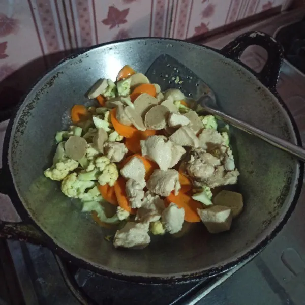 Setelah bumbu matang masukkan air, kol, wortel, bakso dan sosis masak sampai sayur empuk.