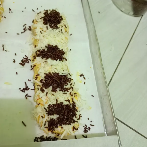 Bungkus pastry menyerupai bentuk kepang. Olesi dengan kuning telur pada seluruh permukaan. Taburi dengan meses dan keju serut