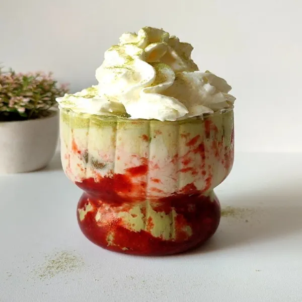 Beri whipped cream di atasnya, bubuk matcha sedikit, strawberry dan daun mint.