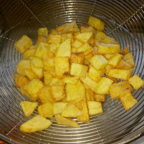 Kupas kulit kentang, lalu potong dadu. Cuci bersih dan tiriskan, kemudian goreng kentang sampai matang dan berwarna kecoklatan,
