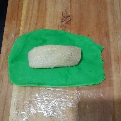 Pipihkan adonan/ digilas beri isian pisang lalu balut rapat.