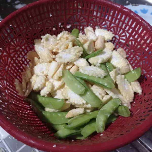 Iris jagung muda, buang bagian pinggiran kapri, cuci bersih, tiriskan.