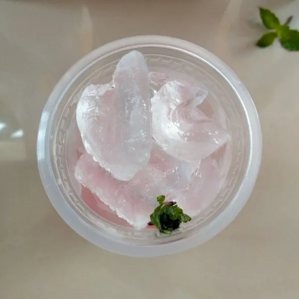 Masukkan sirup strawberry dalam cup ukuran 18 OZ. Lalu masukkan es batu dan daun mint yang sudah diremas-remas.