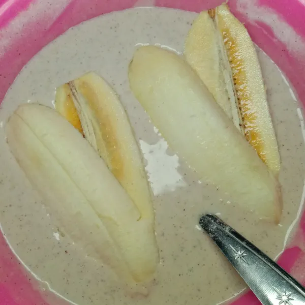 Celupkan ke dalam adonan tepung pisang, baluri hingga menutupi seluruh permukaan pisang.