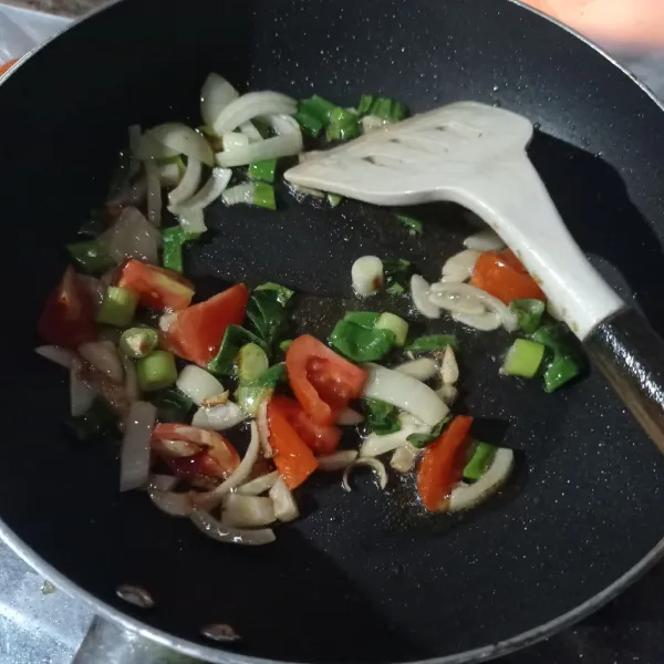 Tumis bawang bombay, bawang putih, daun bawang, dan tomat merah sampai layu.