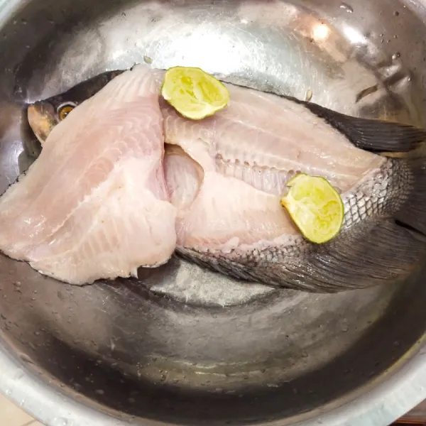 Langkah yang pertama, cuci bersih ikan gurame lalu belah jadi dua lalu lumuri dengan jeruk nipis.
