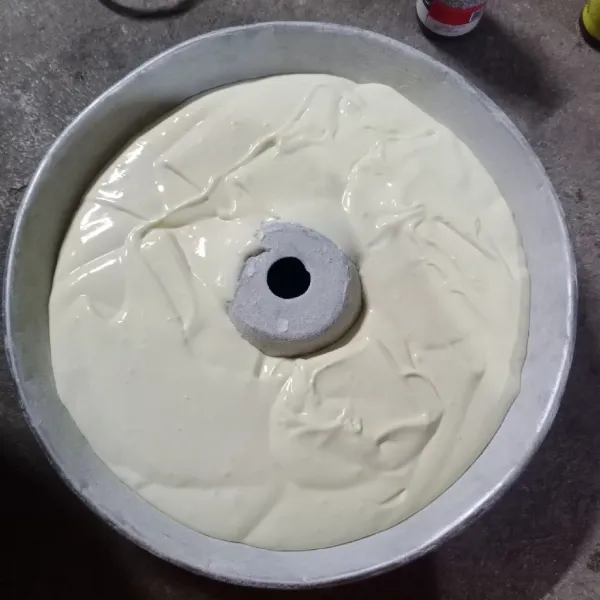 Tuang adonan di loyang yang sudah diolesi margarin dan ditaburi tepung terigu tipis. Sisakan sedikit adonan untuk dicampurkan dengan pasta cokelat.